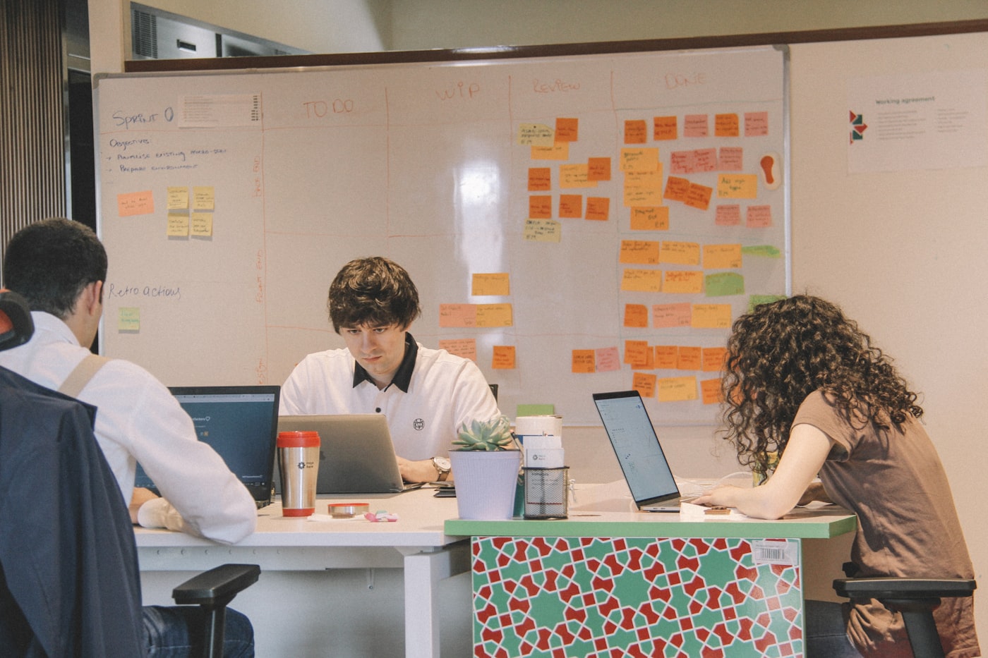 A team working together on laptops during an operations planning session.